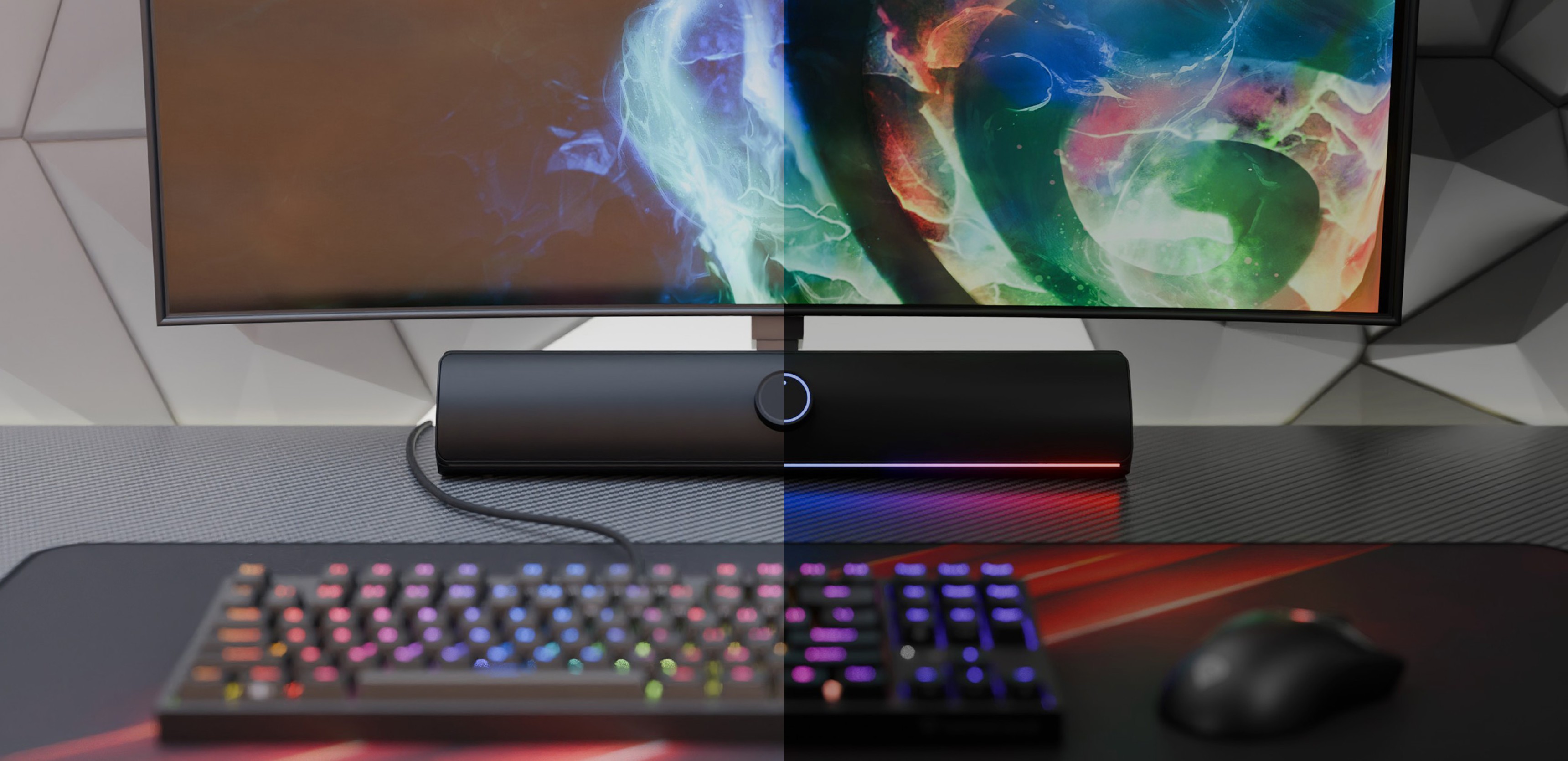 Czarny soundbar Bluetooth umieszczony pod kolorowym monitorem, z gamingową klawiaturą i myszą RGB na biurku