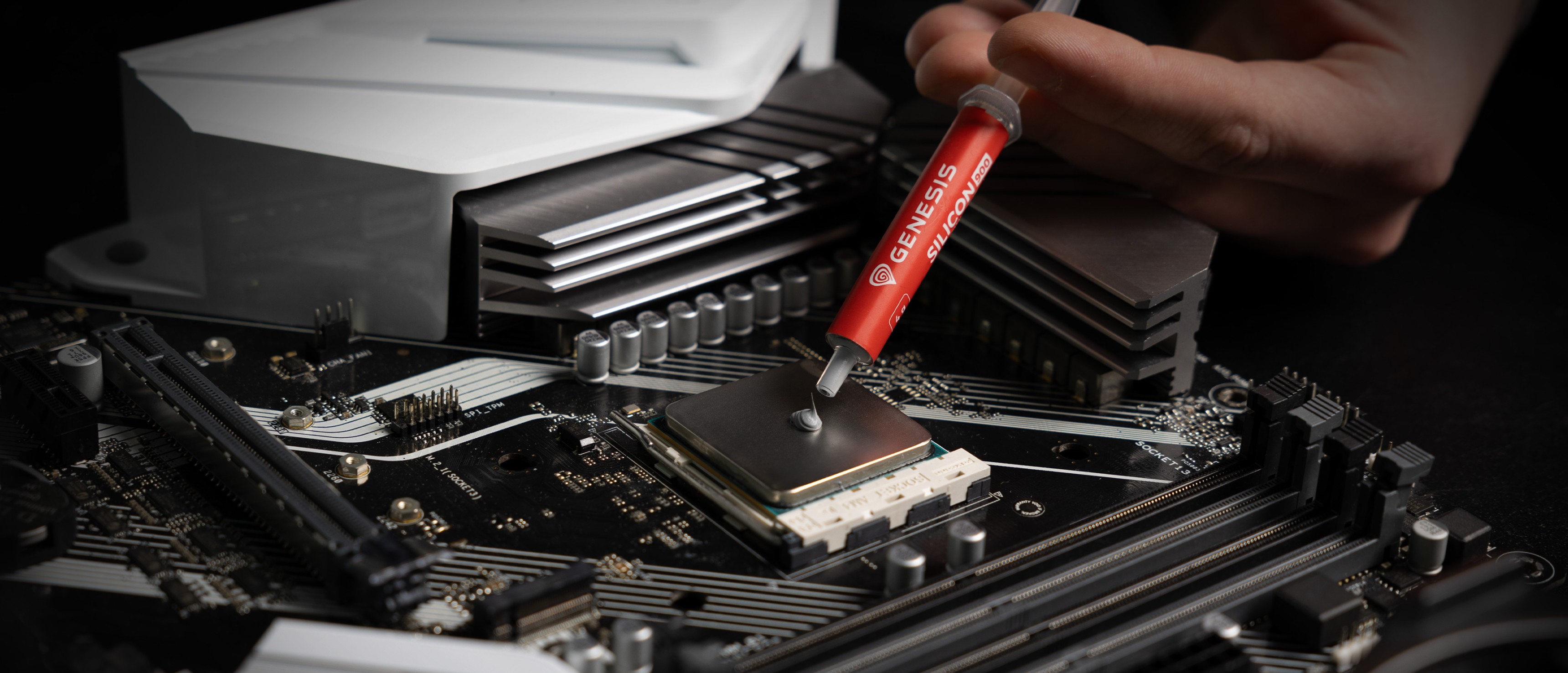Nakładanie pasty termoprzewodzącej Genesis Silicon 900 na gniazdo procesora na płycie głównej w celu poprawy przewodności cieplnej