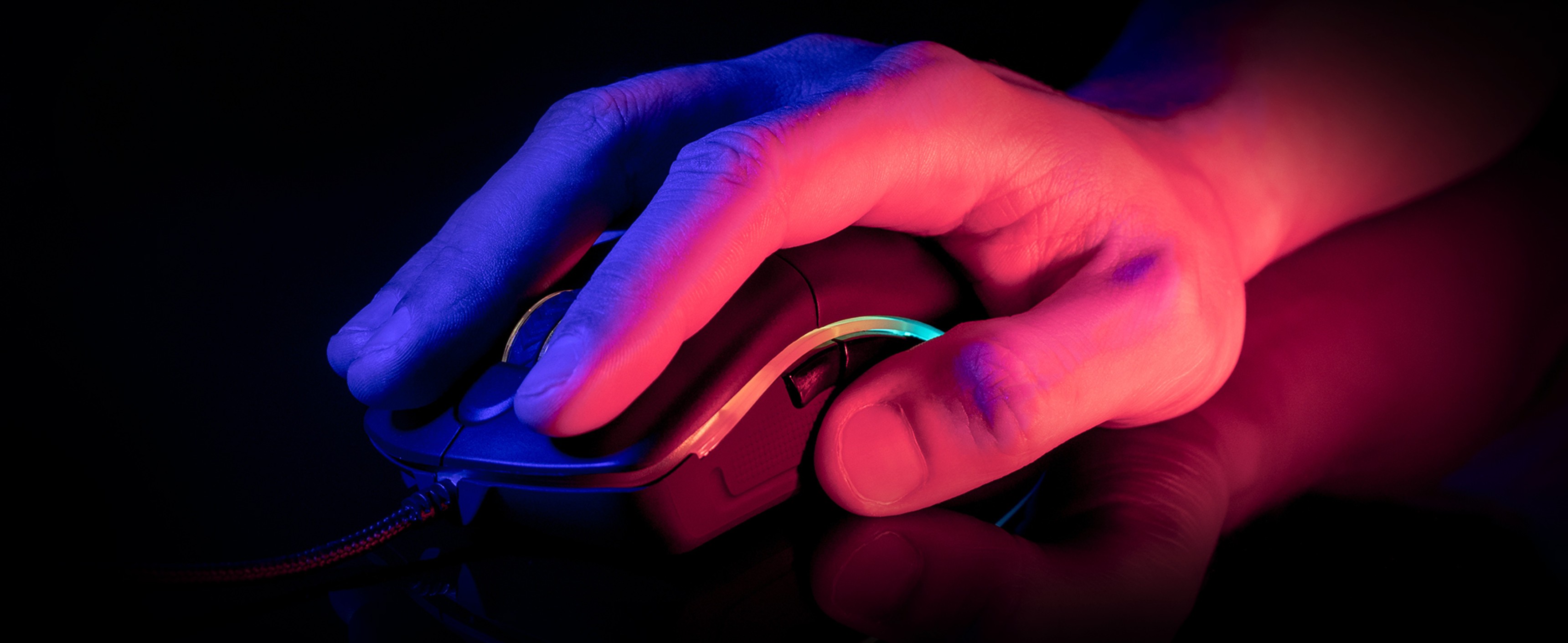 Zbliżenie dłoni używającej czarnej myszy do gier z podświetleniem RGB, odpowiedniej dla graczy, prezentującej ergonomiczną konstrukcję i precyzję.